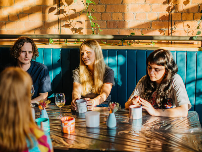 A group of colleagues relax in the winter sunshine at a pottery making class